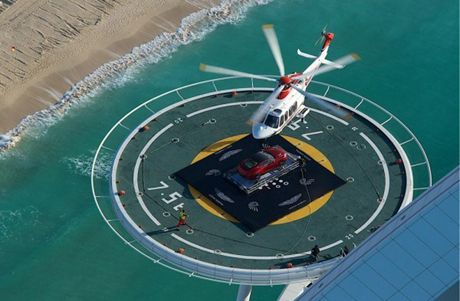 Chiếc Aston Martin được đưa bằng trực thăng lên bãi đáp của khách sạn - Ảnh: Luxurylaunches