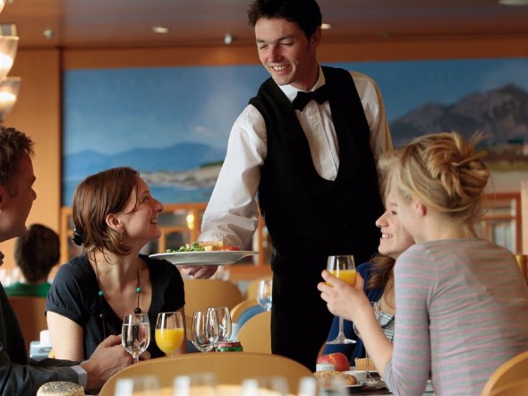 family-eating-in-the-restaurant_-waiter-serving-food-to-the-table_base1-590x442